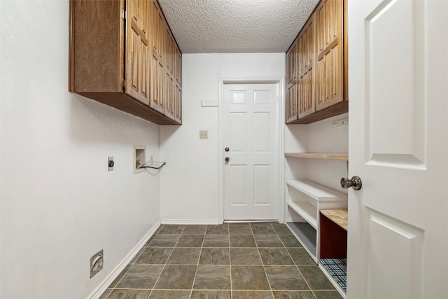 laundry area featuring a textured ceiling, hookup for a washing machine, hookup for an electric dryer, baseboards, and cabinet space