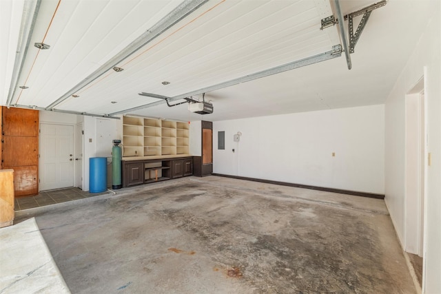 garage with a garage door opener, electric panel, and baseboards