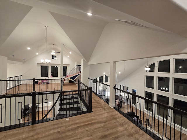 interior space with visible vents, an inviting chandelier, an upstairs landing, wood finished floors, and high vaulted ceiling