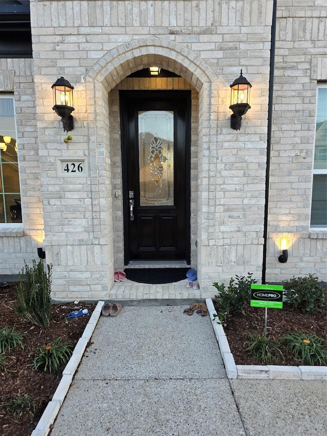 doorway to property with brick siding