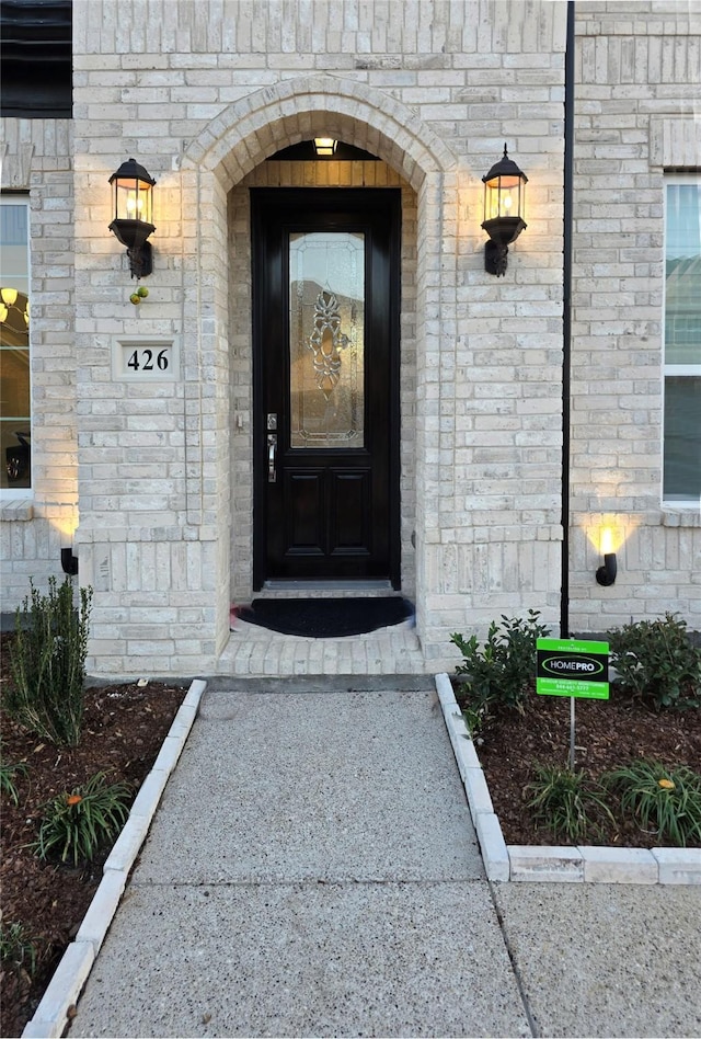 view of exterior entry with brick siding and stone siding