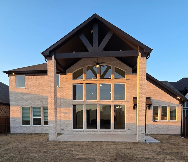 rear view of property featuring ceiling fan, brick siding, and a patio area