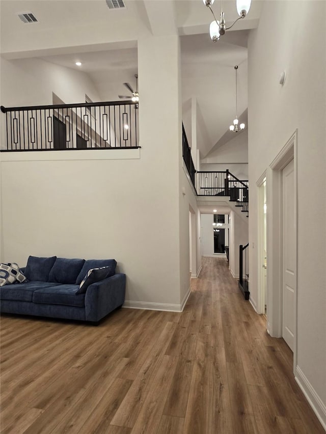 interior space with visible vents, baseboards, wood finished floors, and stairway