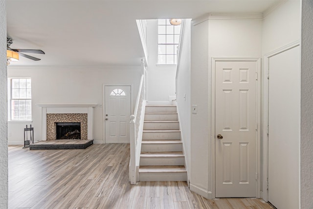 1542 Home Park Dr, Allen, TX 75002 - entrance foyer with stairs, crown molding, a ceiling fan, light wood-style floors, and a tile fireplace