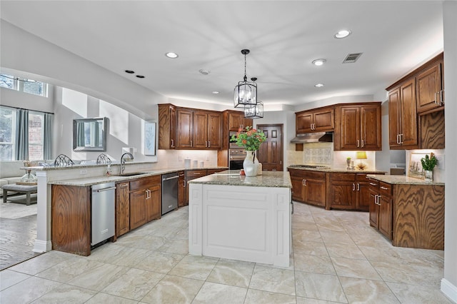 kitchen with a peninsula, a sink, visible vents, under cabinet range hood, and appliances with stainless steel finishes
