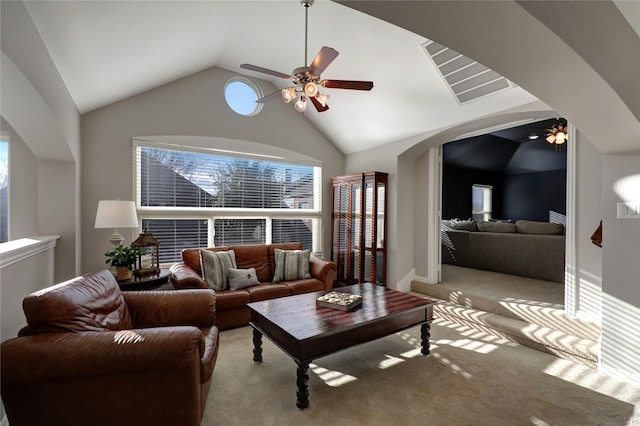 carpeted living area featuring arched walkways, a ceiling fan, and lofted ceiling