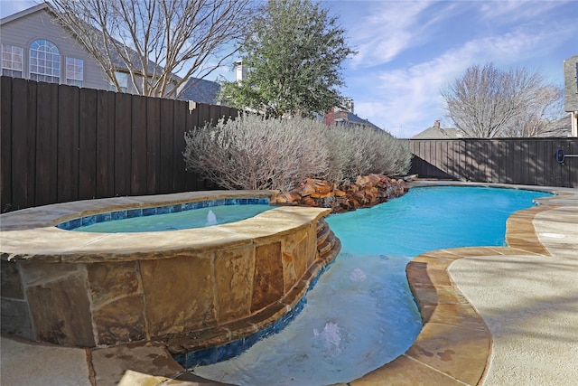 view of swimming pool featuring a fenced backyard and a pool with connected hot tub