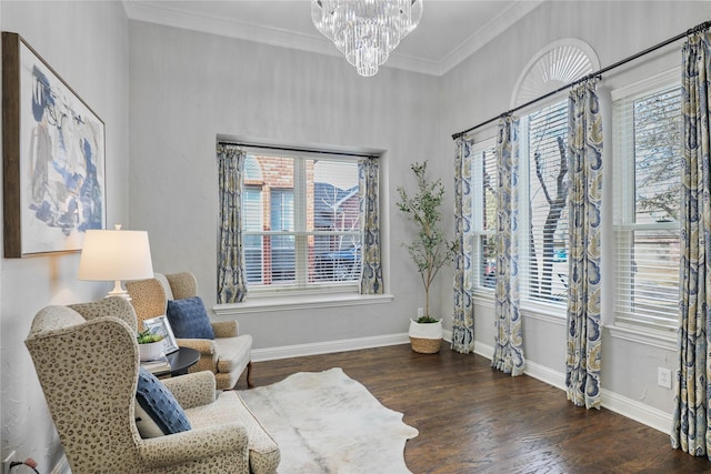 living area featuring a notable chandelier, baseboards, crown molding, and wood finished floors