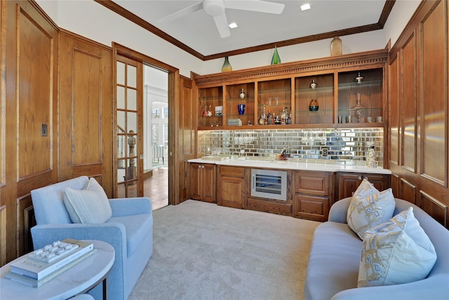 kitchen with carpet, beverage cooler, brown cabinets, and crown molding