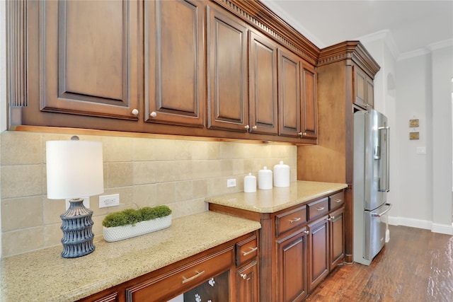 kitchen with dark wood-type flooring, baseboards, ornamental molding, backsplash, and freestanding refrigerator