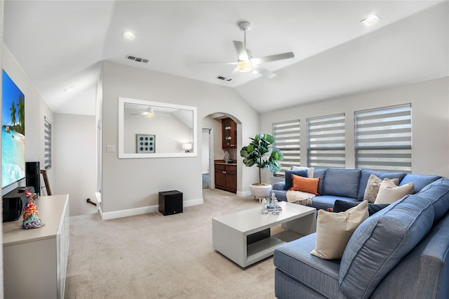 living room with light carpet, visible vents, arched walkways, ceiling fan, and vaulted ceiling