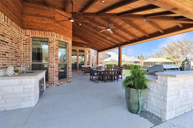 view of patio featuring a sink, area for grilling, a ceiling fan, and outdoor dining space