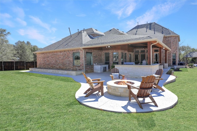 back of house featuring a patio area, an outdoor fire pit, a yard, and brick siding