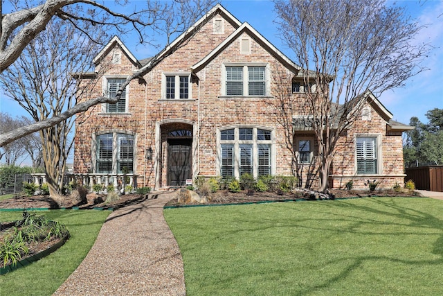 view of front of property with fence, a front lawn, and brick siding