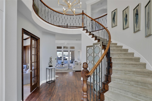 entryway featuring french doors, stairway, a towering ceiling, wood finished floors, and baseboards