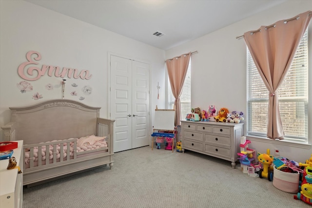 carpeted bedroom with a closet, visible vents, a crib, and multiple windows