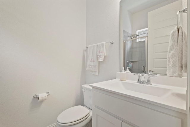 bathroom with an enclosed shower, vanity, and toilet