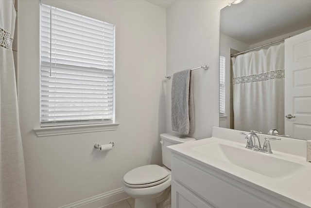 bathroom featuring toilet, baseboards, and vanity