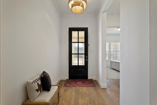 foyer with baseboards, wood finished floors, and crown molding