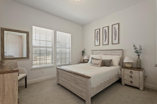 bedroom with baseboards and light colored carpet