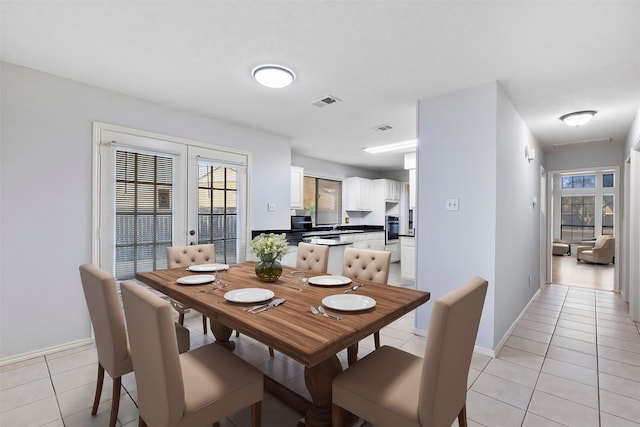 dining space featuring french doors, light tile patterned flooring, visible vents, and a healthy amount of sunlight