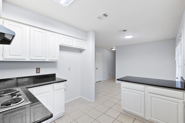 kitchen featuring light tile patterned floors, visible vents, white cabinets, ventilation hood, and stainless steel stovetop