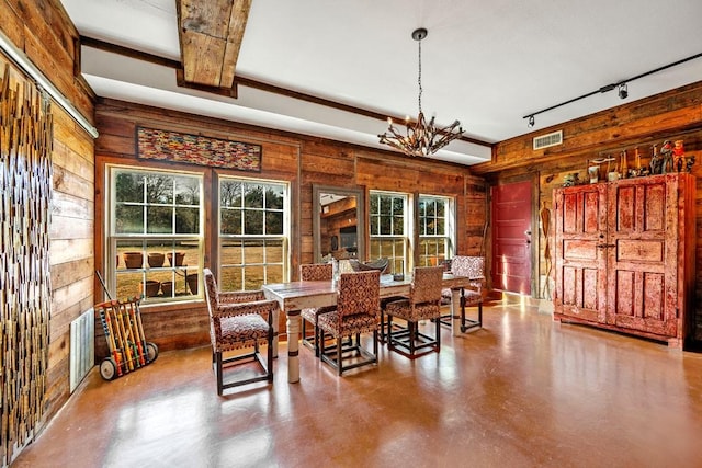 dining area featuring visible vents, concrete floors, wood walls, and rail lighting