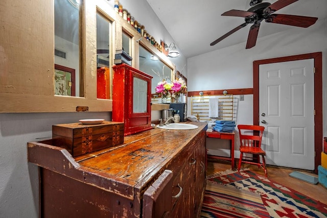 bathroom with lofted ceiling, ceiling fan, vanity, and visible vents