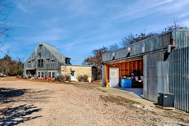 exterior space featuring an outbuilding and dirt driveway