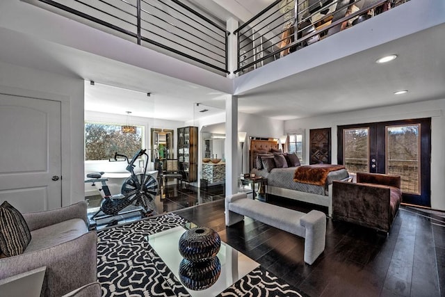 living room featuring recessed lighting, french doors, a high ceiling, and hardwood / wood-style flooring