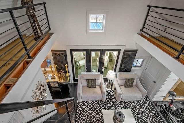 interior space featuring french doors, a high ceiling, and a wealth of natural light