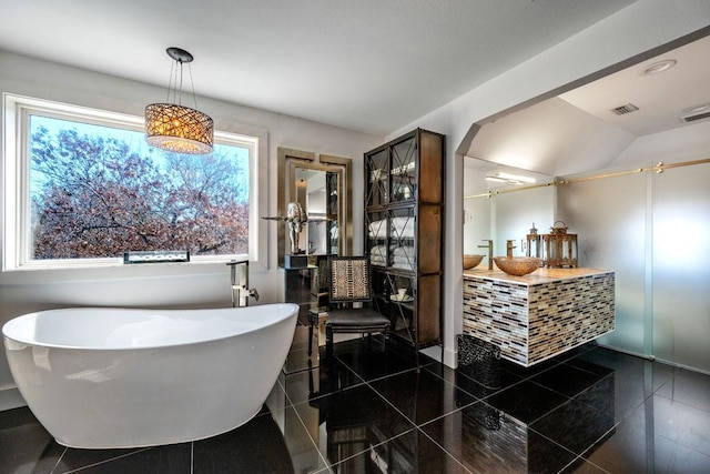 bathroom with a soaking tub, tile patterned floors, visible vents, and vanity