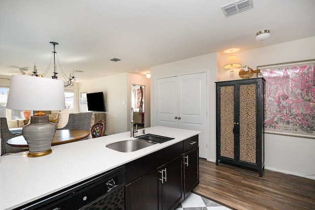 kitchen featuring black dishwasher, light countertops, visible vents, a sink, and dark cabinets