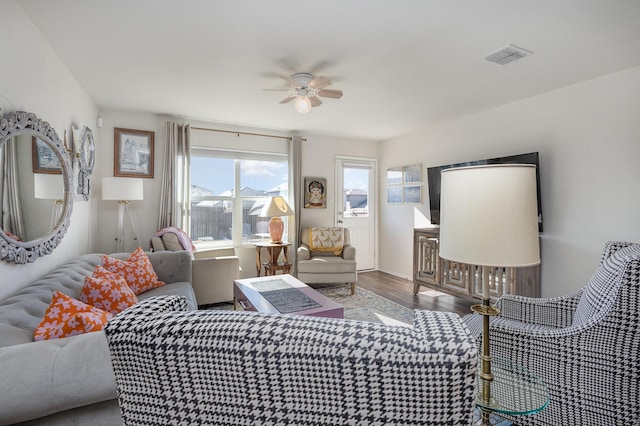 living room with visible vents, ceiling fan, and wood finished floors