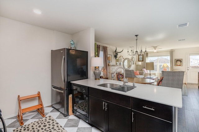 kitchen with a peninsula, a sink, visible vents, light countertops, and dishwasher