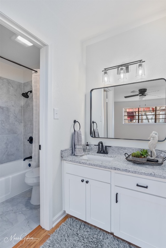 full bathroom featuring toilet, shower / bath combo with shower curtain, a ceiling fan, and vanity