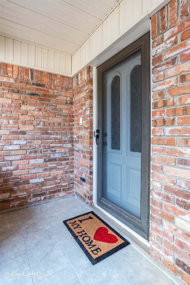 property entrance featuring brick siding