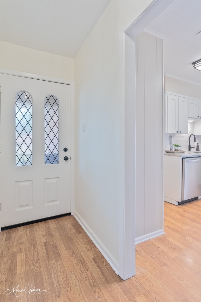 foyer entrance with light wood-type flooring and baseboards