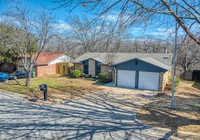 view of front of home featuring a garage, a shingled roof, fence, concrete driveway, and stone siding