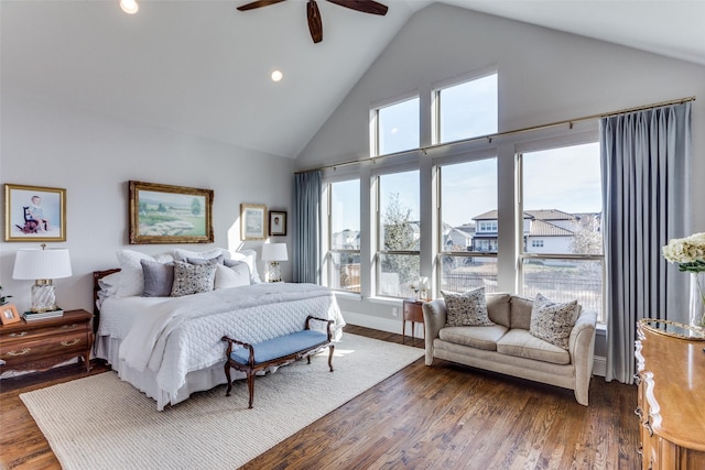 bedroom with high vaulted ceiling, multiple windows, wood finished floors, and a ceiling fan