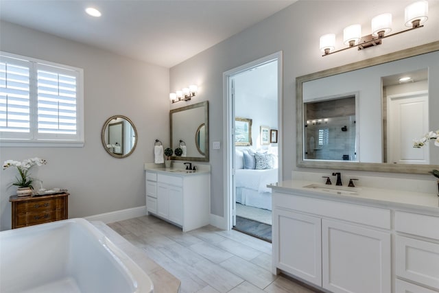 bathroom with a soaking tub, tiled shower, a sink, and ensuite bathroom