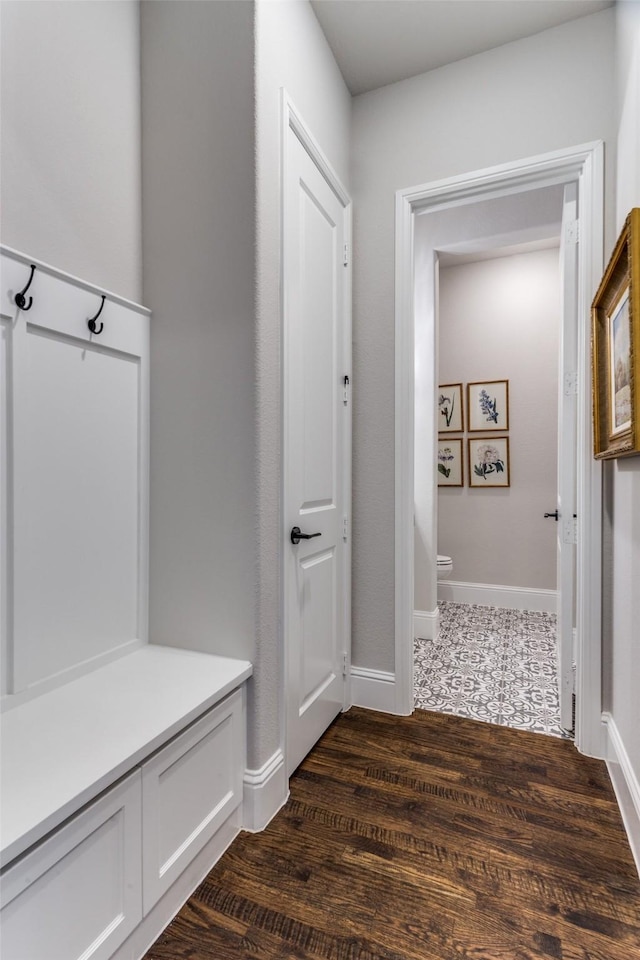 mudroom with dark wood-type flooring and baseboards