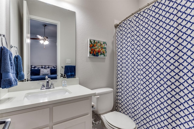 full bath with a textured wall, toilet, ensuite bathroom, a ceiling fan, and vanity