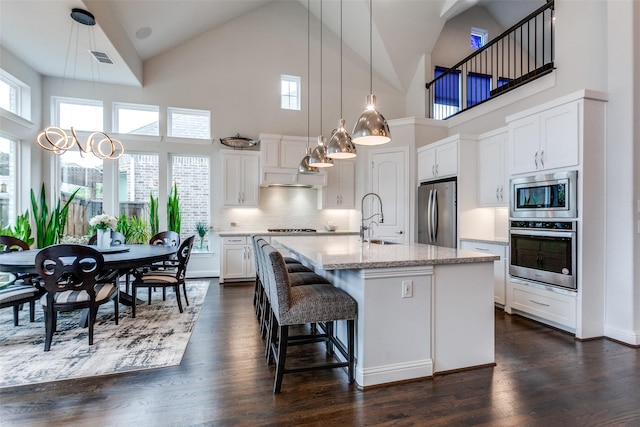 kitchen featuring dark wood-style floors, appliances with stainless steel finishes, a sink, and white cabinets