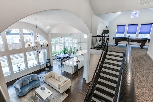 living room with high vaulted ceiling, visible vents, stairway, dark wood-type flooring, and a chandelier