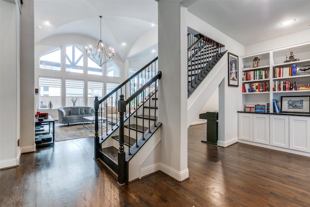 stairway featuring built in features, a chandelier, baseboards, and wood finished floors