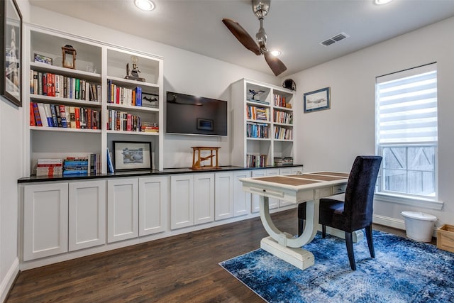 home office with dark wood-style floors, a ceiling fan, visible vents, and baseboards