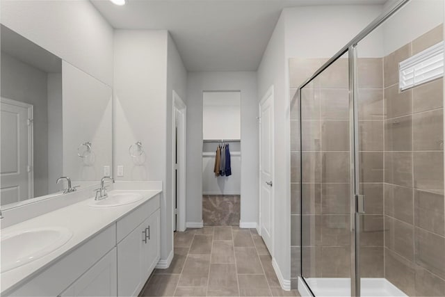 full bathroom featuring a stall shower, a sink, and a spacious closet