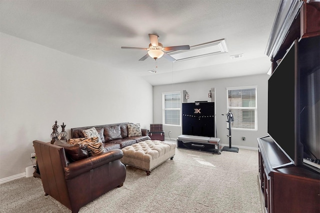 living room featuring a healthy amount of sunlight, a ceiling fan, and light colored carpet