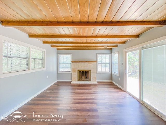 unfurnished living room with a fireplace, plenty of natural light, baseboards, and wood finished floors